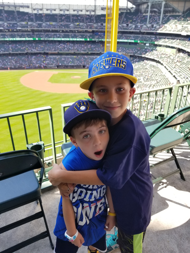 Two children hugging at a Milwaukee Brewers game.