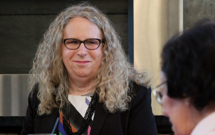 Dr. Rachel Levine faces the camera with a slight smile. She is a white transgender woman with long gray hair and black rimmed glasses.