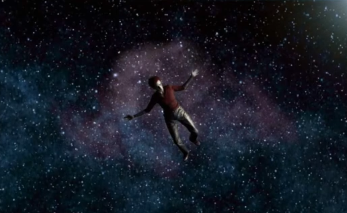 A still image of Matt Bellamy, the lead singer of Muse, falling downward into outer space.